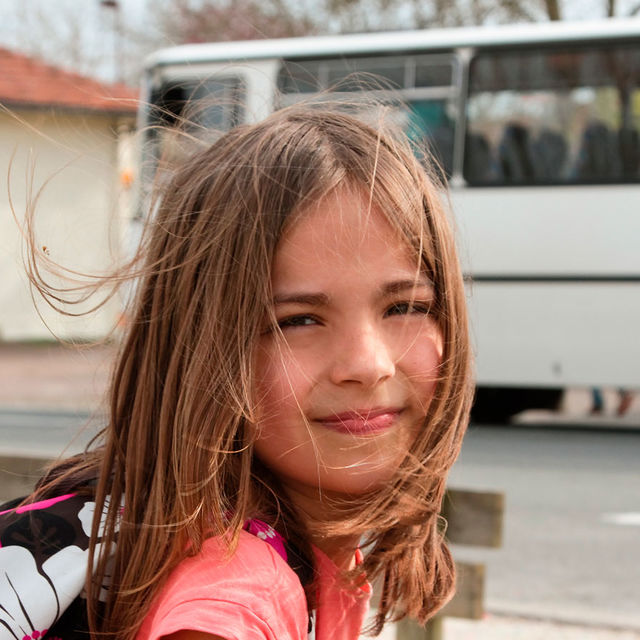 Jeune écolière attendant le bus scolaire.