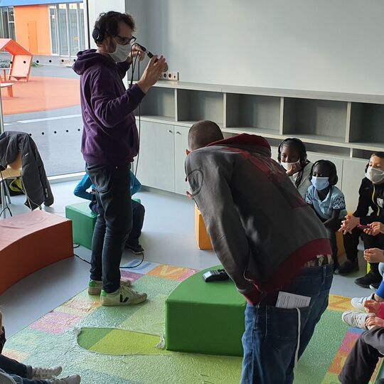 Groupe d'enfants en cercle avec des casques participent à un enregistrement