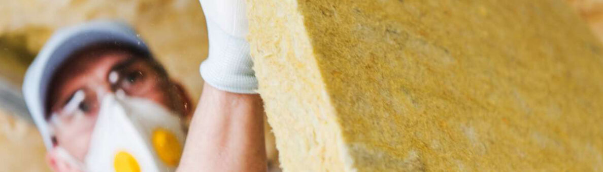 Un homme installe un panneau isolant