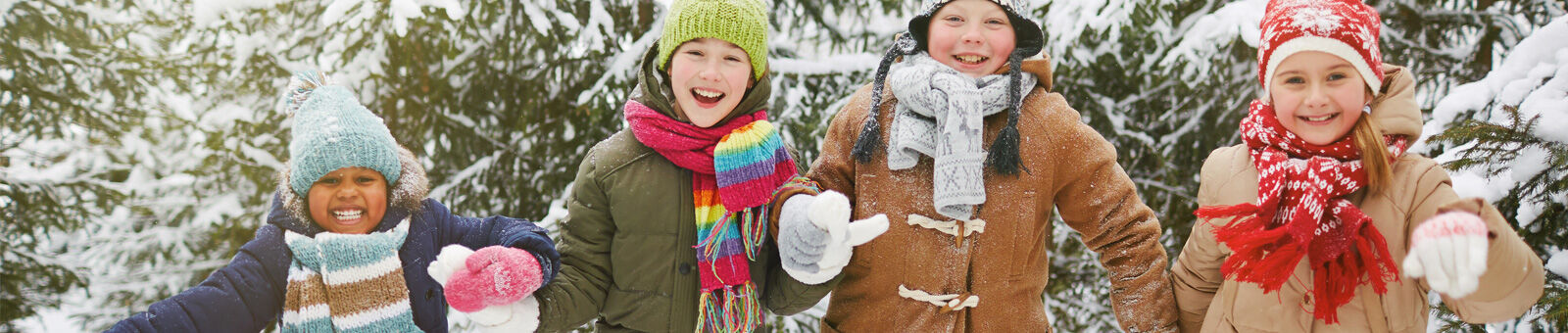 4 enfants se tiennent par la main dans la neige