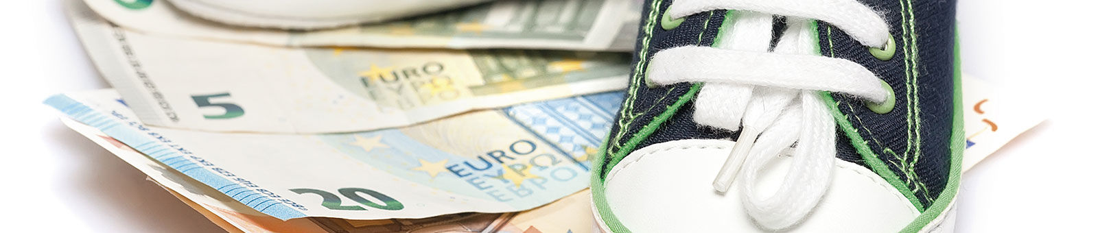 Chaussures de bébé sur des billets de banque.