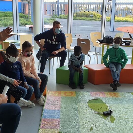 Groupe d'enfants en cercle avec des casques participent à un enregistrement