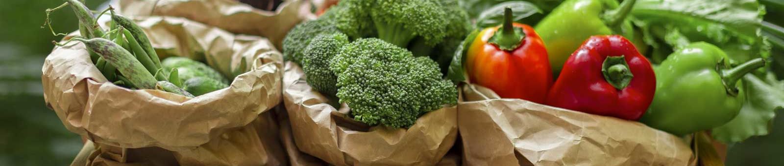 Un commerçant porte un plateau avec des fruits et des légumes